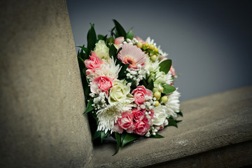 Colorful wedding bouquet lies on the stone balcony