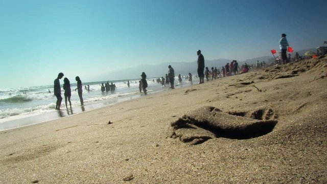 A wide angle view of beach goers on a sunny weekend.