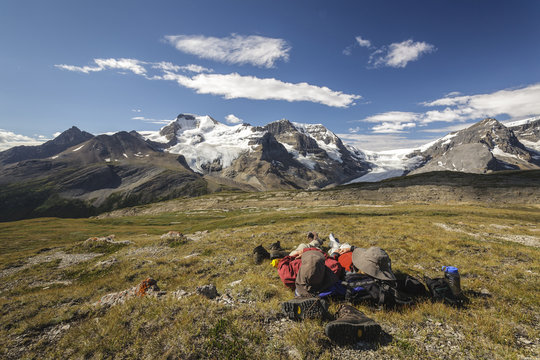 Two hikers relax overlooking Mount Athabasca from the summit of Wilcox Pass in Jasper National Park,Alberta, Canada. Model Released - Powered by Adobe