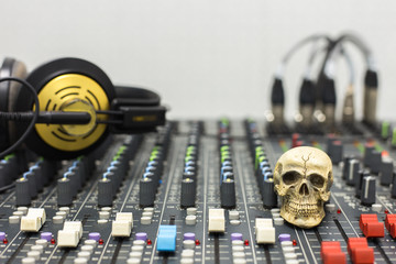 Obraz na płótnie Canvas Human skull resting on a sound mixer