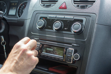 hand turns the car radio
