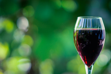 Glass with red wine on the wooden table. Shallow depth of field.