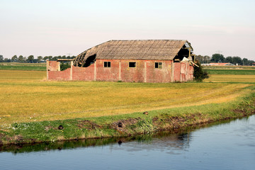 Obraz premium Old barn on a field.