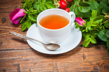 Healthy tea with a dogrose on wooden table