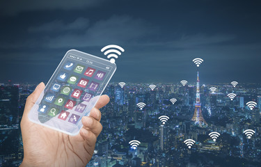 hand holds futuristic transparent smart phone and smart city