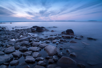 Fototapeta na wymiar Dark stones oh the beach in the evenig