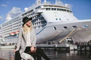 beautiful woman traveler sitting on a suitcase at sea cruise liner