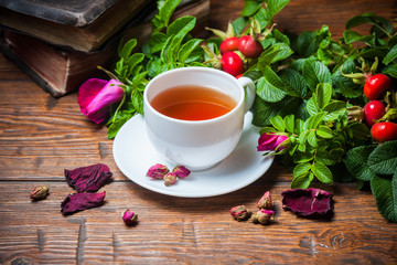 Fototapeta na wymiar Healthy tea with a dogrose on wooden table