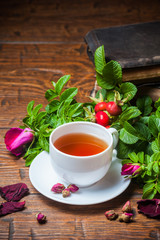 Healthy tea with a dogrose on wooden table