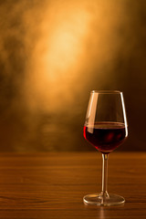 Glass of red wine on gold background