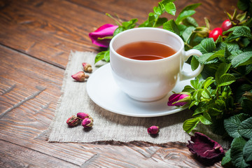 Healthy tea with a dogrose on wooden table