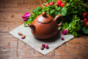 Obraz na płótnie Canvas Healthy tea with a dogrose on wooden table