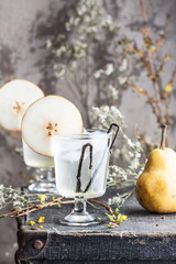 Cold pear cocktail with vanilla, sweet syrop and ice on the old-fashion tray from suitcase
