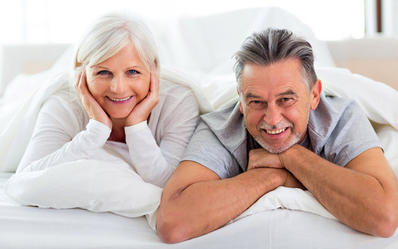 Senior couple lying in bed together
