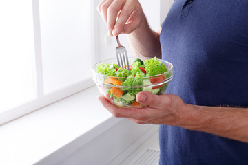 Unrecognizable man has healthy lunch, eating diet vegetable sala