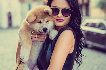 Female holding a dog puppy.