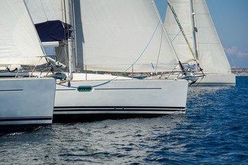 Fototapeta premium Sailing boats is crossing the regatta start line. Mediterranean sea charter racing.