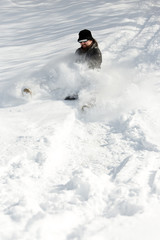 Mann beim Schlitten fahren im tiefen Schnee