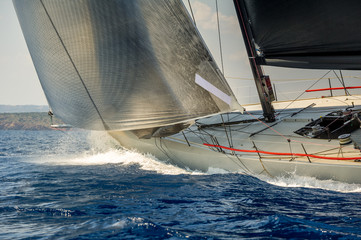 Sailboat bow with hoisted headsail and copy space on the boat hull.