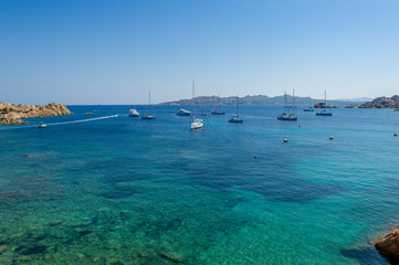 Mediterranean bay with turquoise water and sailing boat anchorage.