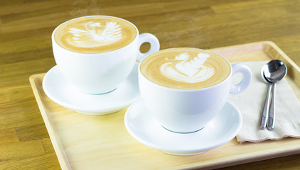Two cup of hot coffee served on tray on wooden table