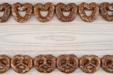 Gingerbread heart cookies on a wooden white background.