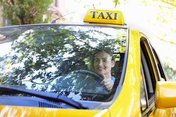 Beautiful female taxi driver sitting in car