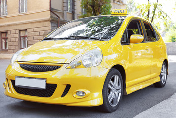 Yellow taxi car on city road