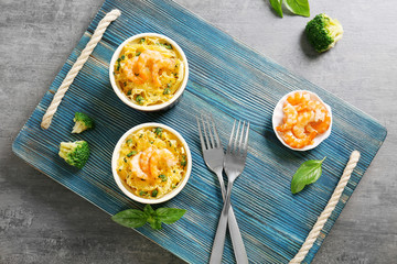 Portions of delicious pasta with shrimps on blue wooden board