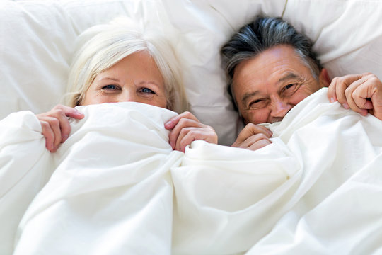 Senior couple lying in bed together
