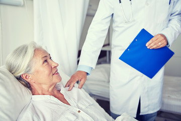 doctor visiting happy senior woman at hospital