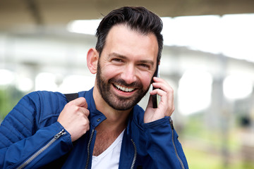 Happy mature man using mobile phone and smiling