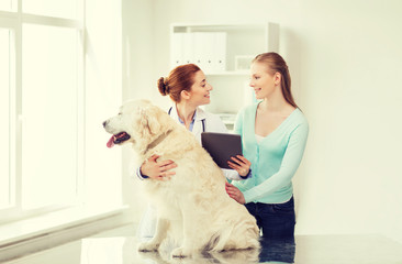 happy woman with dog and doctor at vet clinic