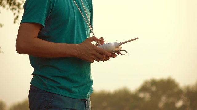 Man using drone RC remote at sunset