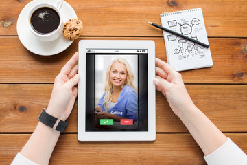 close up of woman with tablet pc on wooden table