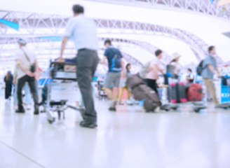 Blurred image of people traveling at airport terminal, People checking in at airport terminal with motion blur