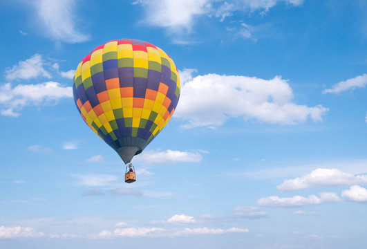 Hot air baloon with clouds blue sky background