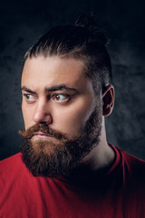 Bearded male in a red t shirt on grey background.