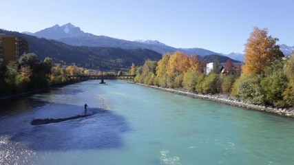Man fishing at the Inn river in Innsbruck, Austria on a sunny autumn morning