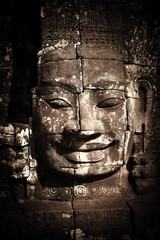 Fototapeta na wymiar Ancient Khmer architecture. Huge carved Buddha faces of Bayon temple at Angkor Wat complex, Siem Reap, Cambodia