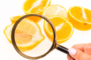 Lemon and a magnifying glass on white background