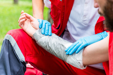 Treatment of burns. Paramedic placing bandage during training. Professional injury make-up