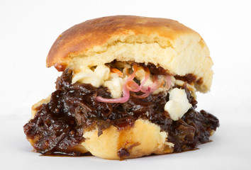 Smoked meat beef sandwich, with barbecue sauce and coleslaw isolated on a white background.