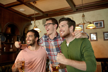 friends with beer watching sport at bar or pub
