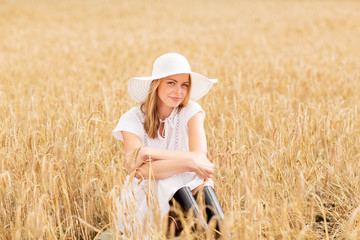Naklejka na ściany i meble happy young woman in sun hat on cereal field