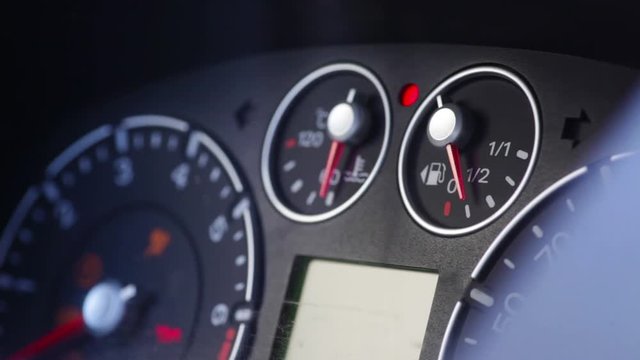 Color close up footage of a car's dashboard, with engine starting.