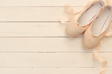 Naklejka premium silk pointe shoes on white wooden background