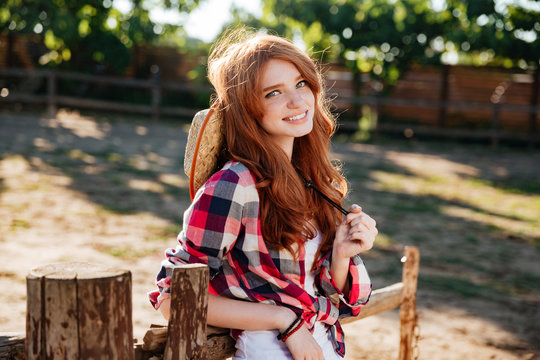 Cheerful beautiful young woman cowgirl on ranch