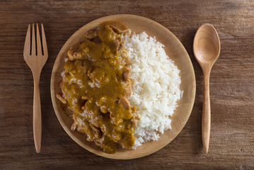 Beef in curry sauce and rice on a plate.