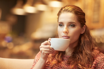 Young beautiful woman in the cafe. Warm colors.